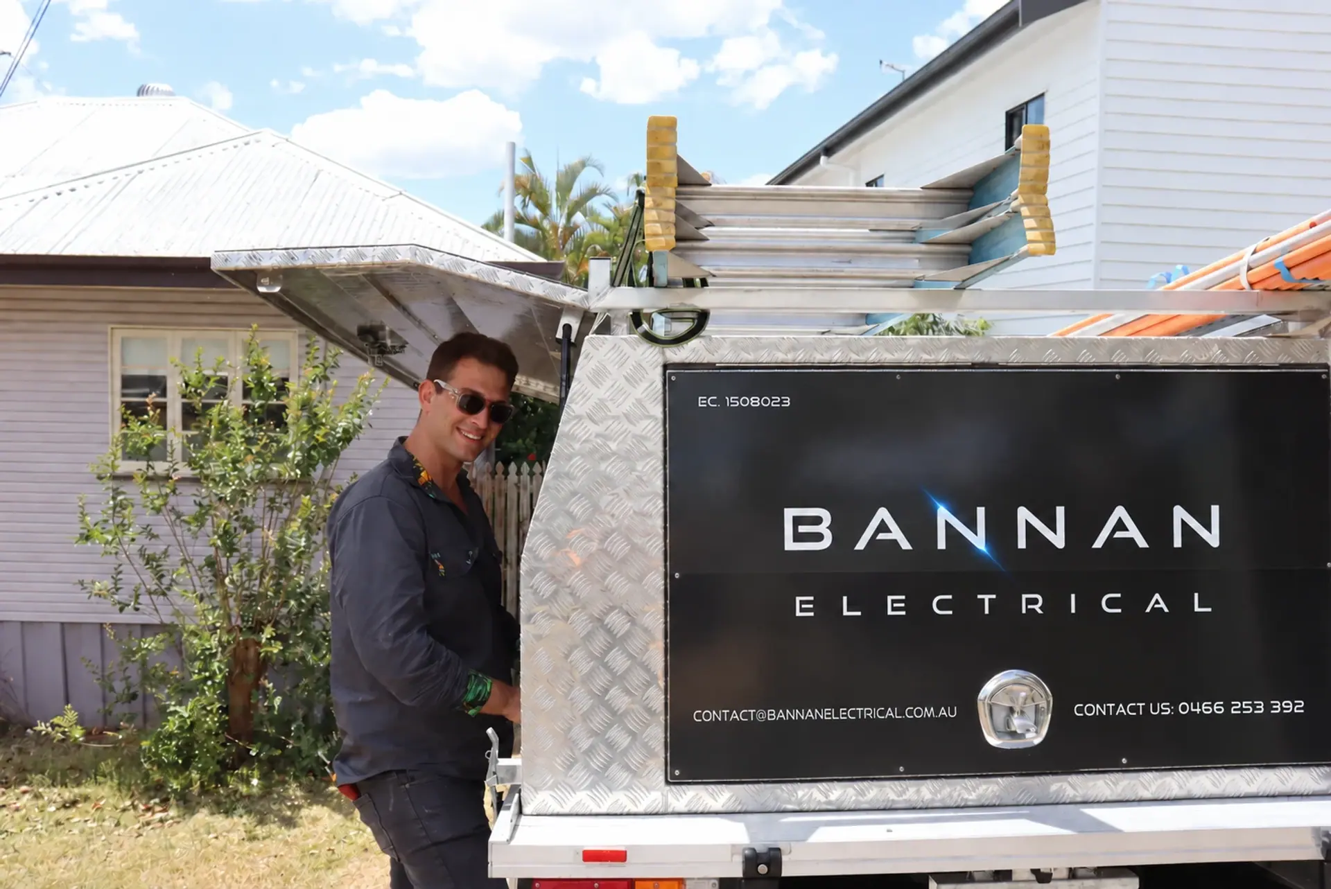 Bannan Electrical electrician standing beside the company’s branded work ute